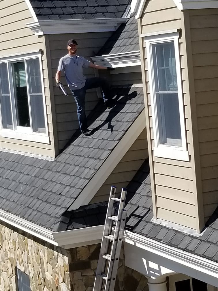 A man standing on the roof of a house.