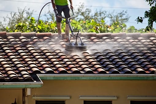 A man is cleaning the roof of a house