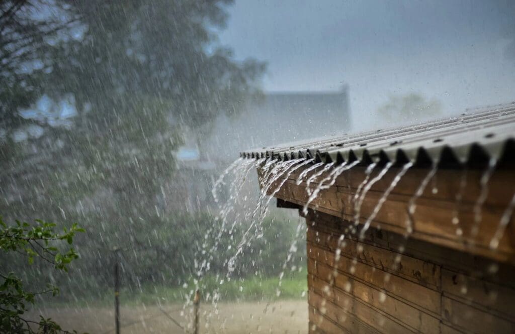 A rain shower is pouring on the roof of a house.