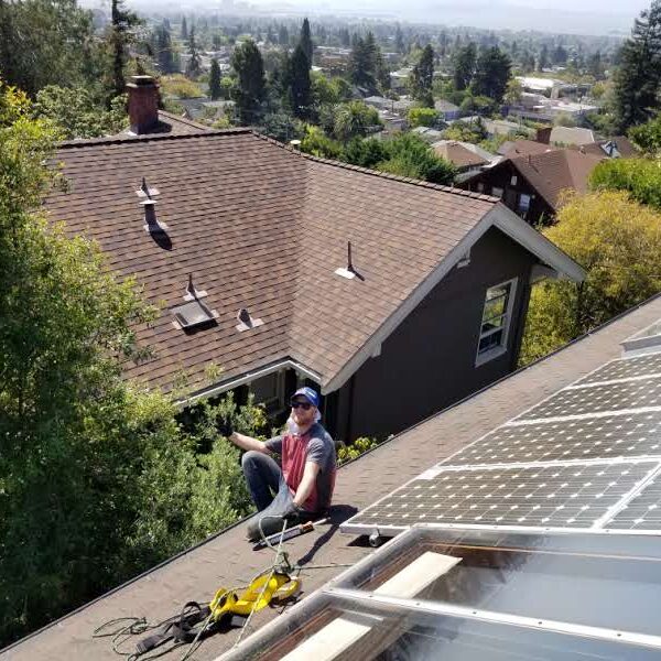 A technician performs professional roof cleaning using soft-washing techniques.