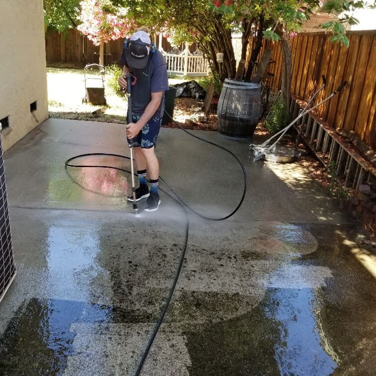 A professional technician performs roof cleaning on a residential home.