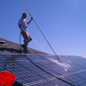 A professional cleans the roof during roof cleaning.